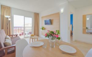 un soggiorno con tavolo e fiori di Apartamentos Centro Cancajos a Los Cancajos