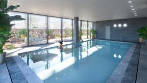 - une grande piscine d'eau bleue dans un bâtiment dans l'établissement Domitys Quarto Verde, à Bergame