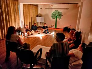 un grupo de personas sentadas en una habitación en Holy River Hotel, en Rishīkesh