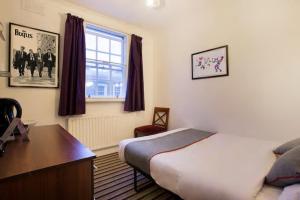 sypialnia z łóżkiem, biurkiem i oknem w obiekcie Enrico Hotel w Londynie
