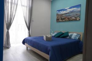 una camera blu con un letto e una finestra di Cristal Home a Napoli