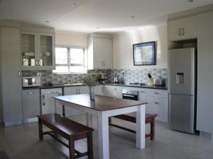 una cocina grande con mesa y sillas. en Mayfair Farm Cottages, en Oudtshoorn