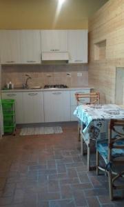una cocina con armarios blancos y una mesa con sillas. en Borgo Piazza, en Catanzaro Lido
