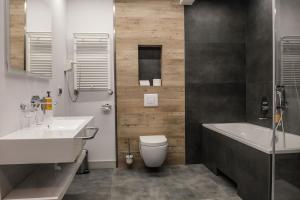 a bathroom with a sink and a toilet and a tub at Hotel Europa Starachowice in Starachowice