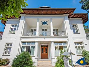 a white house with a balcony on top of it at Villa Linde Whg 06 in Heringsdorf