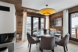 uma sala de jantar com uma mesa e cadeiras e uma lareira em Appartement Ourson - LES CHALETS COVAREL em Val dʼIsère