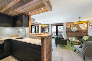 an open kitchen and living room in a house at Appartement Ourson - LES CHALETS COVAREL in Val dʼIsère +16 photos