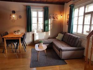 ein Wohnzimmer mit einem Sofa und einem Tisch in der Unterkunft Villa Zeppelin - App Smaragd in Bramberg am Wildkogel
