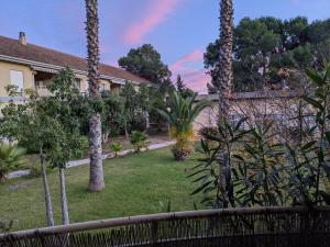a garden with palm trees and a fence at Apartamento zona residencial Montesol in La Eliana
