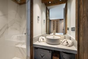 uma casa de banho com um lavatório e um chuveiro em Appartement Ourson - LES CHALETS COVAREL em Val dʼIsère