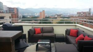 a balcony with couches and a view of a city at Calle 8 Suites in Medellín