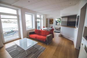 a living room with a red couch and a table at Appartement sainte marine vue mer in Combrit