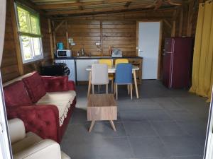 a living room with a couch and a table and a kitchen at La maison du nord, T2 privé in Mtsangadoua
