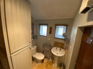 a bathroom with a white toilet and a sink at Hideaway Cottage in Whitby