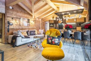 a living room with a yellow couch and a kitchen at The Kaprun Edition - Luxury Chalets & Style Suites in Kaprun