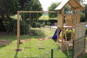 a playground with two swings in a yard at Die Kleine Villa in Zimmert