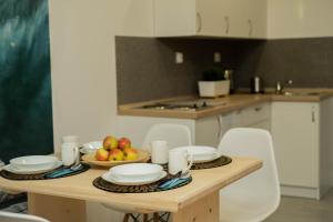 eine Küche mit einem Tisch mit Tellern und Obst darauf in der Unterkunft Apartamenty GoszoWita in Stronie Śląskie