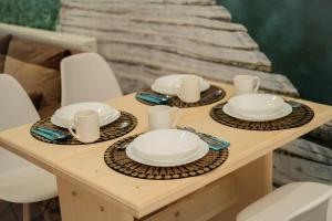einen Tisch mit Tellern und Tassen und Geschirr darauf in der Unterkunft Apartamenty GoszoWita in Stronie Śląskie
