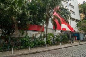 a building with a palm tree in front of a street at OYO Rio Colinas Hotel, Rio de Janeiro in Rio de Janeiro