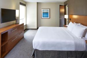 兰辛Hyatt Place Lansing-East的配有一张大床和一台平板电视的酒店房间