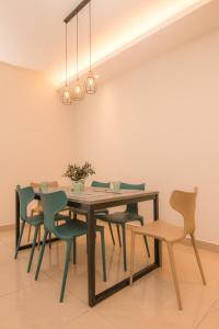 comedor con mesa de madera y sillas en Cameron Highlands Modern7-Tea Plantation View-Premium Hotel Bed en Kampung Kuala Terla