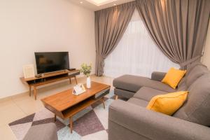 Cameron Highlands Modern7-Tea Plantation View-Premium Hotel Bed في Kampung Kuala Terla: غرفة معيشة مع أريكة وتلفزيون