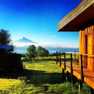 a building with a view of a mountain in the distance at Karibuni - Familiar Lodging & Private Spa in Villarrica
