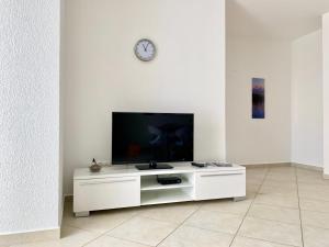 ein weißes Entertainment-Center mit einem TV an einer weißen Wand in der Unterkunft Apartments Maric in Vodice