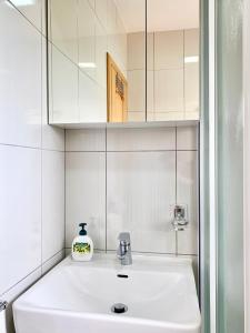 ein Badezimmer mit einem weißen Waschbecken und einem Spiegel in der Unterkunft Apartments Maric in Vodice