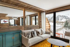 a living room with a couch and a table at Appartement Flocon - LES CHALETS COVAREL in Val dʼIsère