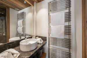 a bathroom with a sink and a mirror at Appartement Flocon - LES CHALETS COVAREL in Val dʼIsère