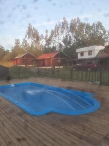 uma grande piscina azul num quintal em Cabañas Tornagaleones Villarrica em Villarrica
