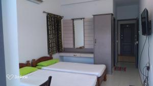 a small room with two beds and a mirror at THE ALP HOTEL in Madurai +38 photos