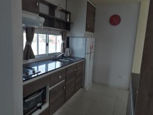 una cocina con fregadero y refrigerador en Departamentos37Depto1, en Santa Teresita 2 fotos más