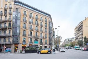 a yellow car is parked in front of a building at Sibs Bcn- Universitat- Cosmopolitan LGTB Cozy in Barcelona