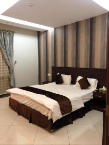 a large bedroom with a large bed with white sheets at Masa Homes Furnished Apartments in Al Madinah