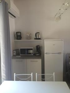 a small kitchen with a refrigerator and two chairs at Peri village in Peri