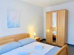 ein Schlafzimmer mit einem Bett und einer Kommode mit Spiegel in der Unterkunft Apartments Maric in Vodice