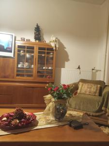 uma sala de estar com um sofá e uma mesa com flores em Maria 's home em Heraclião