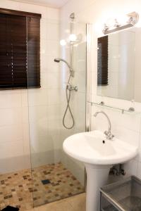 a bathroom with a sink and a shower at Kunuku Villa in Oranjestad