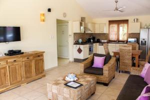 a living room with a couch and a kitchen at Kunuku Villa in Oranjestad