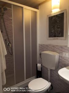 a bathroom with a toilet and a shower and a sink at Casa Tellina lungomare scogliera in Aci Castello