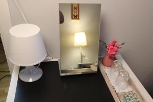 una mesa con una lámpara y un espejo. en The Viking Country Club, en Hjalteyri