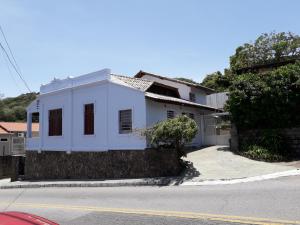 una casa blanca al lado de una calle en Aparts Ilha Centro-casa 2 qtos e casa 1 qto mezanino, en Florianópolis