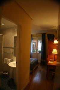 a room with a bathroom with a bed and a sink at Pensión Bilbao in Bilbao