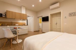 a bedroom with a bed and a table and a kitchen at Aqualago casa vacanze apartment A in Verbania