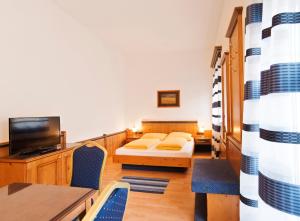 Zimmer mit einem Bett, einem Tisch und Stühlen in der Unterkunft Hotel Hottentotten in Regensburg