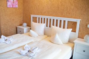 a white bed with a white comforter and pillows at Hotel Vicinity in Neubrücke