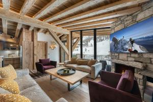 uma sala de estar com lareira e televisão em Penthouse Flèche - LES CHALETS COVAREL em Val dʼIsère