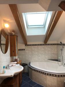La salle de bains est pourvue d'une baignoire, d'un lavabo et d'une lucarne. dans l'établissement Appartement Leirer, à Alpbach